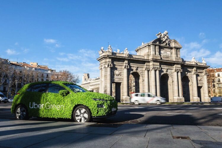 Coche de Uber 'ecologista' con carrocería de hojas verdes ante la Puerta de Alcalá de Madrid