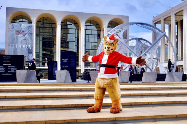 Un Santa Claus peludo ante la Ópera de Nueva York, con una noria a la derecha.