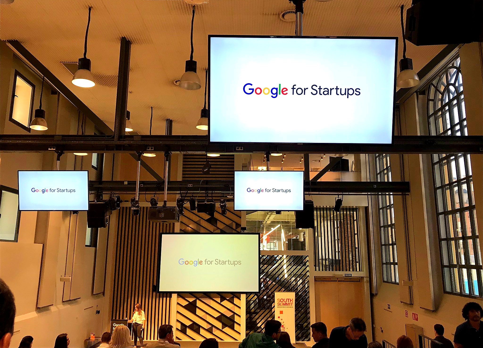 Interior de un centro tecnológico Google en Madrid, con cuatro pantallas con el lema: "·Google for Startups".