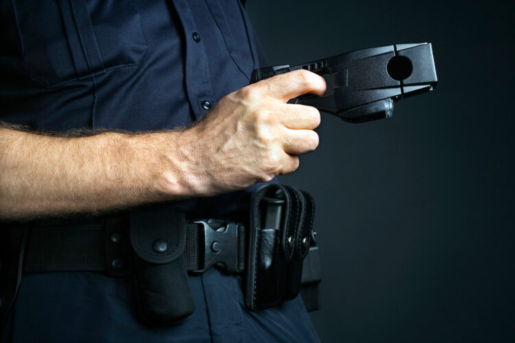 un policía empuña una pistola eléctrica